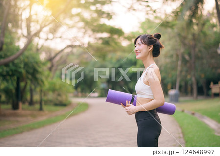 pretty fitness yoga woman in the park with yoga mat 124648997