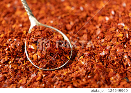 Crushed red hot chili pepper natural seasoning in a spoon 124649960