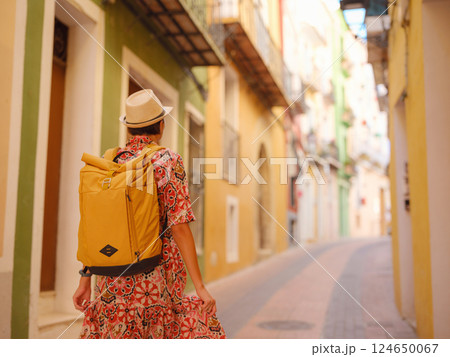 Woman strolls through colorful streets of Spanish coastal town 124650067