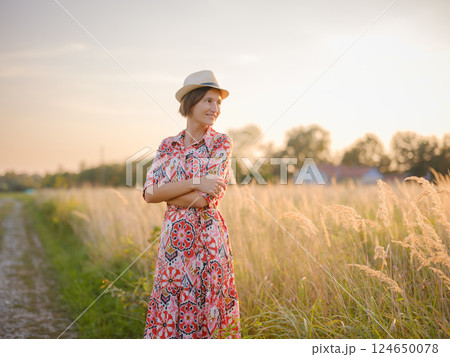 boho chic woman in a floral dress in European countryside boho chic woman in a floral dress in European countryside 124650078