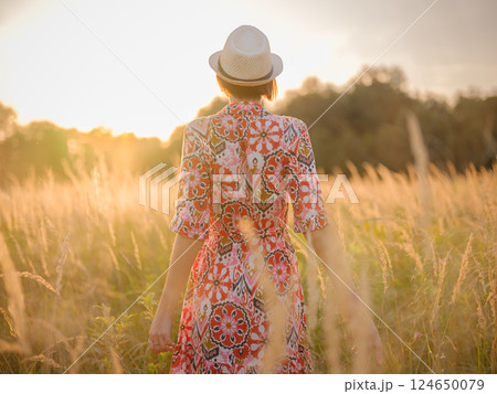 boho chic woman in a floral dress in European countryside 124650079