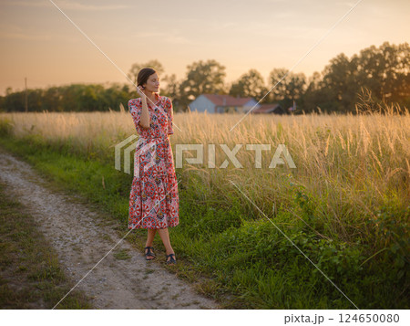 boho chic woman in a floral dress in European countryside 124650080