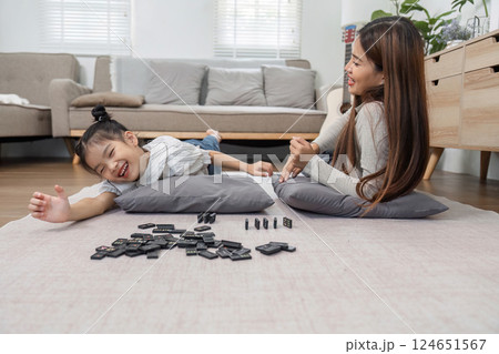 Family Joy and Game Night. A lively scene of a mother and daughter playing together on the floor, emphasizing the importance of quality time. Family Joy and Game Night. A lively scene of a mother and daughter playing together on the floor, emphasizing the importance of quality time. 124651567