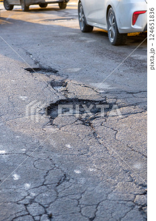 potholes in the road, holes in the asphalt on the roadway or highway. potholes in the road, holes in the asphalt on the roadway or highway. 124651836