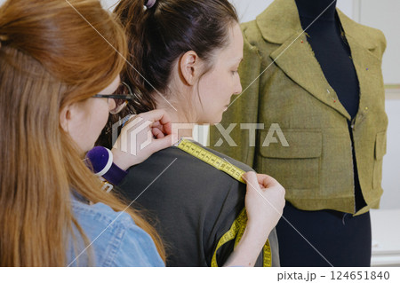 Atelier sewing workshop. female seamstress, fashion designer, takes measurements . 124651840