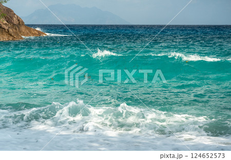 Vibrant turquoise ocean waves rolling onto the shore at Anse Major, Mahe island, Seychelles Vibrant turquoise ocean waves rolling onto the shore at Anse Major, Mahe island, Seychelles 124652573