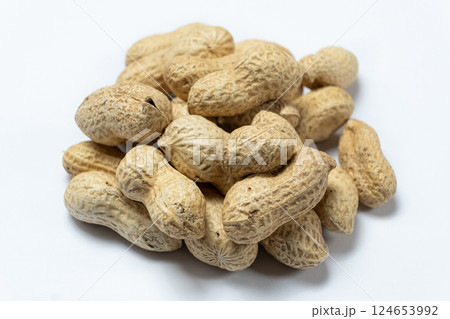 Pile of unpeeled peanuts in shell close-up on white background. 124653992