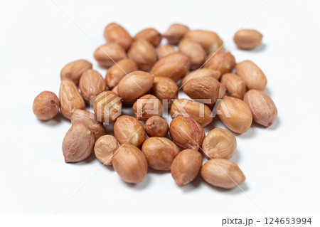 Raw peanut kernels in brown peel on white background macro Raw peanut kernels in brown peel on white background macro 124653994