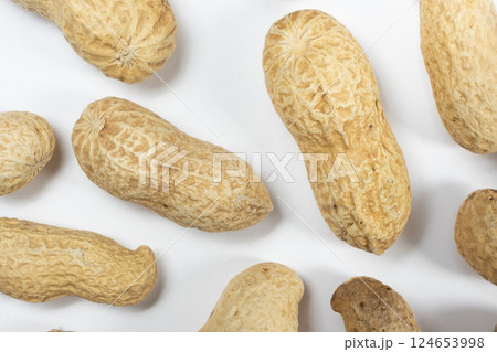 Macro whole unpeeled peanuts on a white background. Macro whole unpeeled peanuts on a white background. 124653998