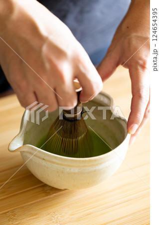 Making matcha tea with bamboo whisk. Making matcha tea with bamboo whisk. 124654395
