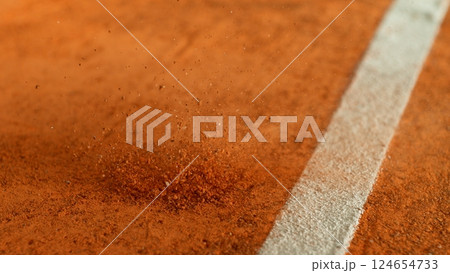 Freeze Motion Detail Shot of Tennis Ball Hitting a Clay Court 124654733