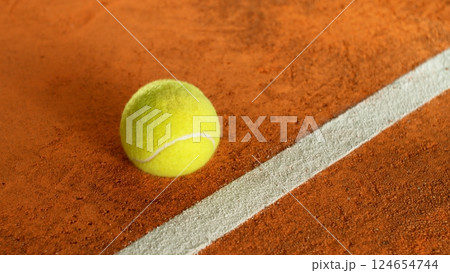 Freeze Motion Detail Shot of Tennis Ball Hitting a Clay Court 124654744