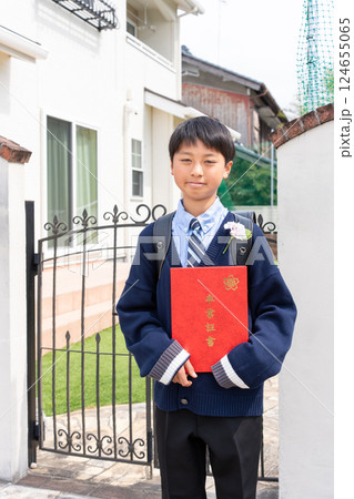 自宅の前で卒業証書を持つ小学生の男の子 自宅の前で卒業証書を持つ小学生の男の子 124655065