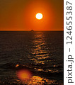 Sunset over ocean with a boat and shimmering golden water 124655387