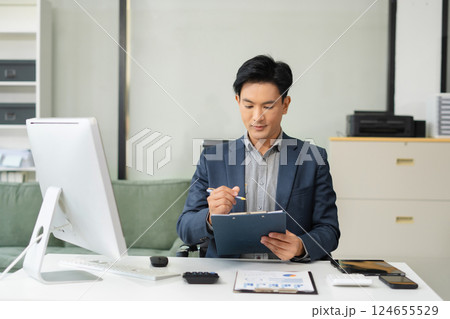 Mature businessman calculate and analyzing graph document financial with report and laptop in office. 124655529
