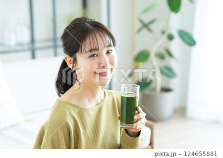 リビングで青汁を飲む若い女性 124655881