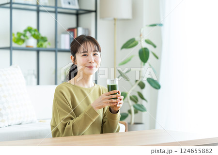 リビングで青汁を飲む若い女性 リビングで青汁を飲む若い女性 124655882
