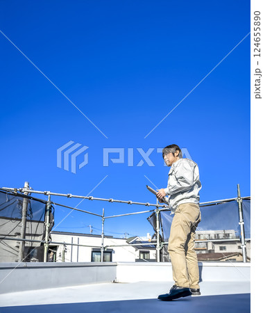戸建て家屋の屋根修理工事の男性現場監督者 戸建て家屋の屋根修理工事の男性現場監督者 124655890