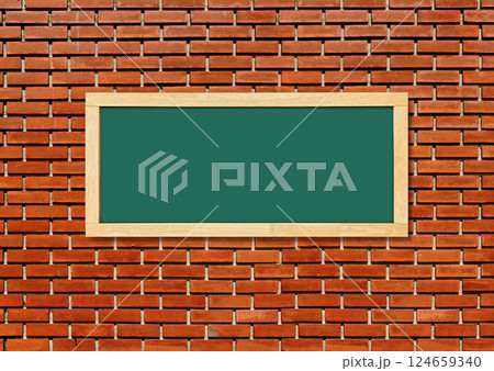 Blank green chalkboard isolated on red brick wall background. 124659340