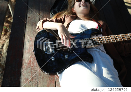 Girl Plays Bass Musical Instrument Lying On Table In Mountains Girl Plays Bass Musical Instrument Lying On Table In Mountains 124659793