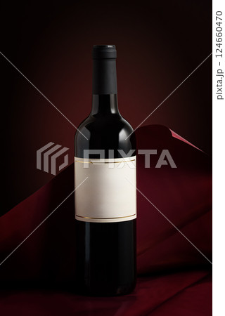 Bottle of red wine on dark red background. Front view Bottle of red wine on dark red background. Front view 124660470