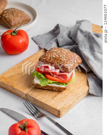 Toast sandwich made of grain bread with prosciutto, cheese, tomatoes, lettuce and sauce 124661077