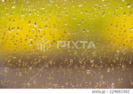 Raindrops on glass against a vibrant background Raindrops on glass against a vibrant background 124661302