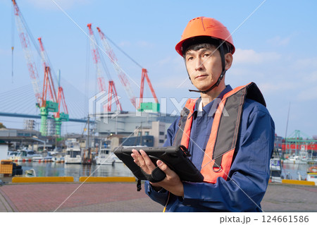 ライフジャケットとヘルメットを着用した港湾作業者 124661586