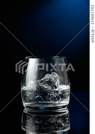 Vodka with ice on a black reflective background. Vodka with ice on a black reflective background. 124661701