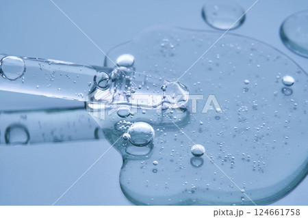 Pipette with serum on a blue background. Product texture. 124661758