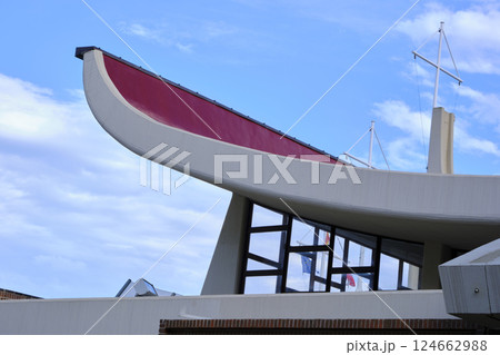 Boat shaped modern building roof with red top and blue sky 124662988