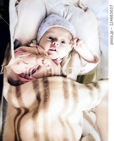 Retro photo. Small three-month-old baby lies in a stroller. Vintage portrait from 1967. 124663037