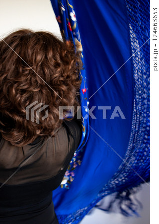 Elegant dance with blue flamenco shawl by female performer 124663653
