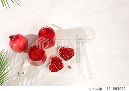 Fruit pomegranate juice and ingredients, summer pomegranate drink on bright table, detox diet and weight loss concept, healthy and natural food, source of vitamin C, selective focus, space for text. Fruit pomegranate juice and ingredients, summer pomegranate drink on bright table, detox diet and weight loss concept, healthy and natural food, source of vitamin C, selective focus, space for text. 124663682