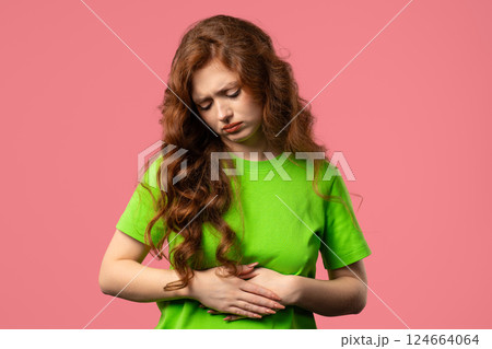 Young woman squeezing belly with hands. abdominal pain, suffering stomach ache 124664064