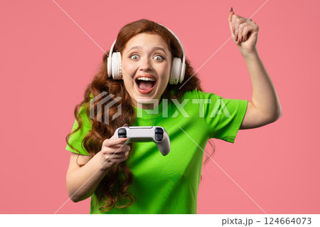 Young gamer woman playing, winning online video game console, happy win, gamepad 124664073