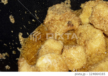 Close up of crispy frying chicken being fried in a batter in a pan 124664165