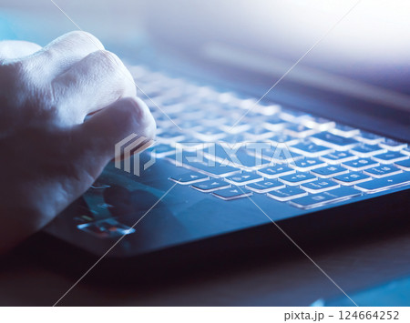 Man works on a laptop at night, hands close up. Man works on a laptop at night, hands close up. 124664252