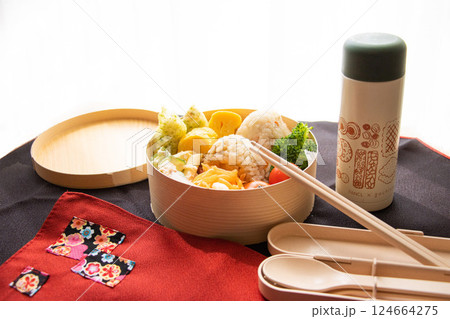 明るい日差しを浴びて丸わっぱのおにぎり弁当 124664275