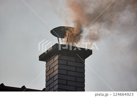 Smoking Chimney on a Roof 124664923