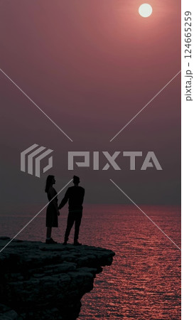 Romantic Couple Silhouette at Sunset on a Cliff 124665259
