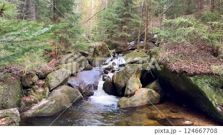 Serene and peaceful streams flowing gracefully through the rocky forest terrain landscape Serene and peaceful streams flowing gracefully through the rocky forest terrain landscape 124667708
