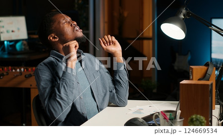 Researcher exhausted after working overtime to finish tasks on schedule. African American under pressure with stress from the leadership team, overcome major difficulties remotely. Camera B. Researcher exhausted after working overtime to finish tasks on schedule. African American under pressure with stress from the leadership team, overcome major difficulties remotely. Camera B. 124669534