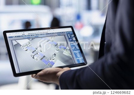 Technician using tablet to monitor solar panel plant assembly lines. Close up of employee using touchscreen device to troubleshoot photovoltaic equipment, ensuring seamless production workflow Technician using tablet to monitor solar panel plant assembly lines. Close up of employee using touchscreen device to troubleshoot photovoltaic equipment, ensuring seamless production workflow 124669682