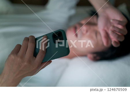 ベッドでスマホを見る男性 ベッドでスマホを見る男性 124670509