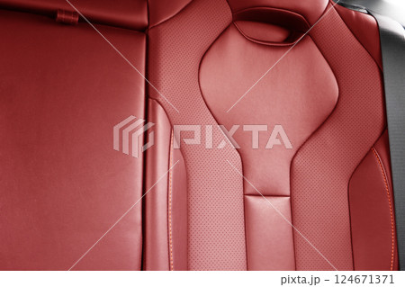 Back passenger red seats in modern luxury car. Red perforated leather with white stitching. Car details. Leather comfortable seats. Car interior details Back passenger red seats in modern luxury car. Red perforated leather with white stitching. Car details. Leather comfortable seats. Car interior details 124671371