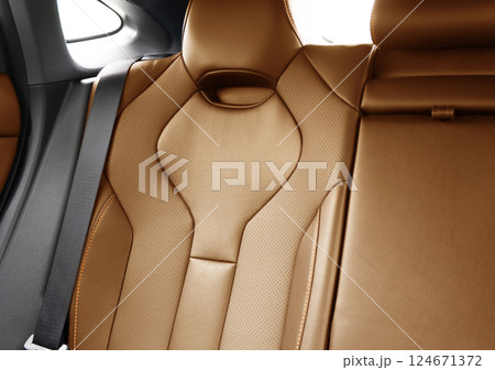 Back passenger brown seats in modern luxury car. Brown perforated leather with white stitching. Car details. Leather comfortable seats. Car interior details Back passenger brown seats in modern luxury car. Brown perforated leather with white stitching. Car details. Leather comfortable seats. Car interior details 124671372