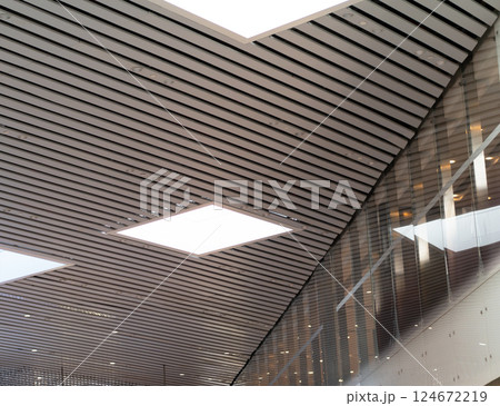 Lights and ventilation system in long line on ceiling of the industrial building. Exhibition Hall. Ceiling factory construction Lights and ventilation system in long line on ceiling of the industrial Lights and ventilation system in long line on ceiling of the industrial building. Exhibition Hall. Ceiling factory construction Lights and ventilation system in long line on ceiling of the industrial 124672219