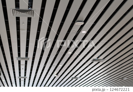 Lights and ventilation system in long line on ceiling of the industrial building. Exhibition Hall. Ceiling factory construction	Lights and ventilation system in long line on ceiling of the industrial 124672221