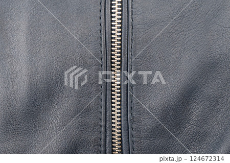 Macro shot of zipper on black leather texture background with stitching. Close-up of black leather material Macro shot of zipper on black leather texture background with stitching. Close-up of black leather material 124672314
